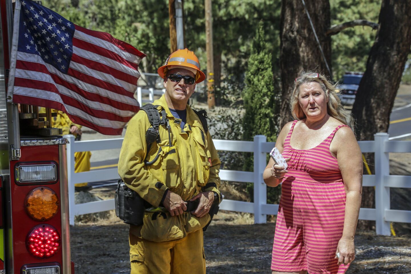 Firefighter Bryan Hagan and Pegi Fall, standing along Lone Pine Canyon Road, watch as the Blue Cut fire approaches Wrightwood. Fall has decided to stay as long as conditions allow.