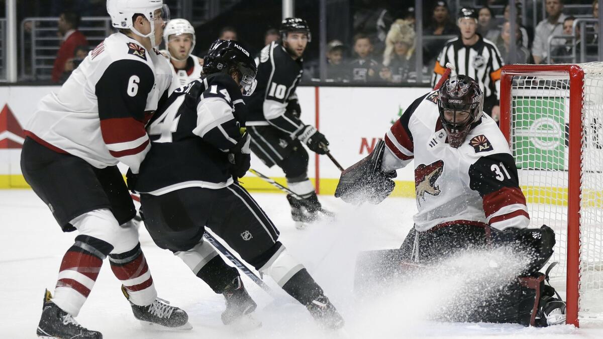 Arizona Coyotes goaltender Adin Hill, right, stops a shot from Kings' Brendan Leipsic, center, during the second period on Tuesday.