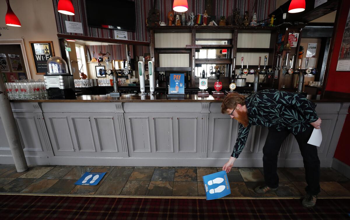 Social distance markers are placed in front of the bar at the Chandos Arms pub in London.