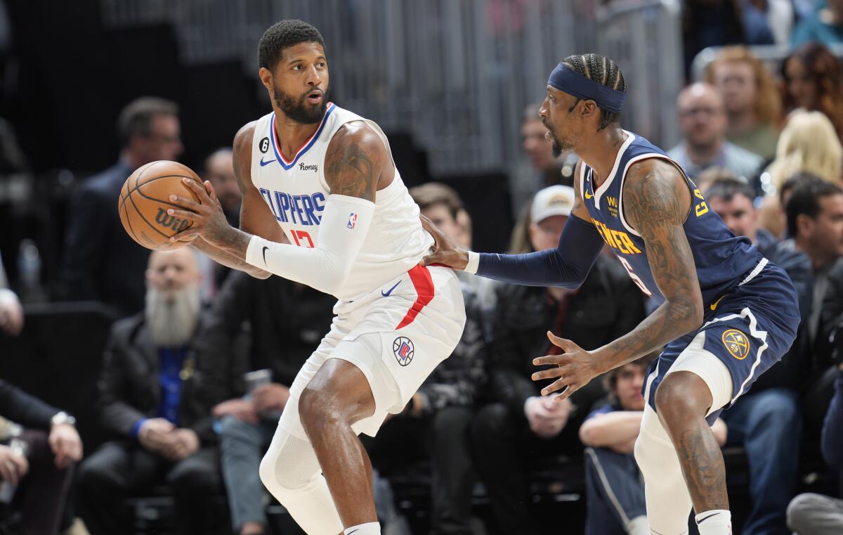 Clippers forward Paul George looks to pass around Denver Nuggets guard Kentavious Caldwell-Pope.