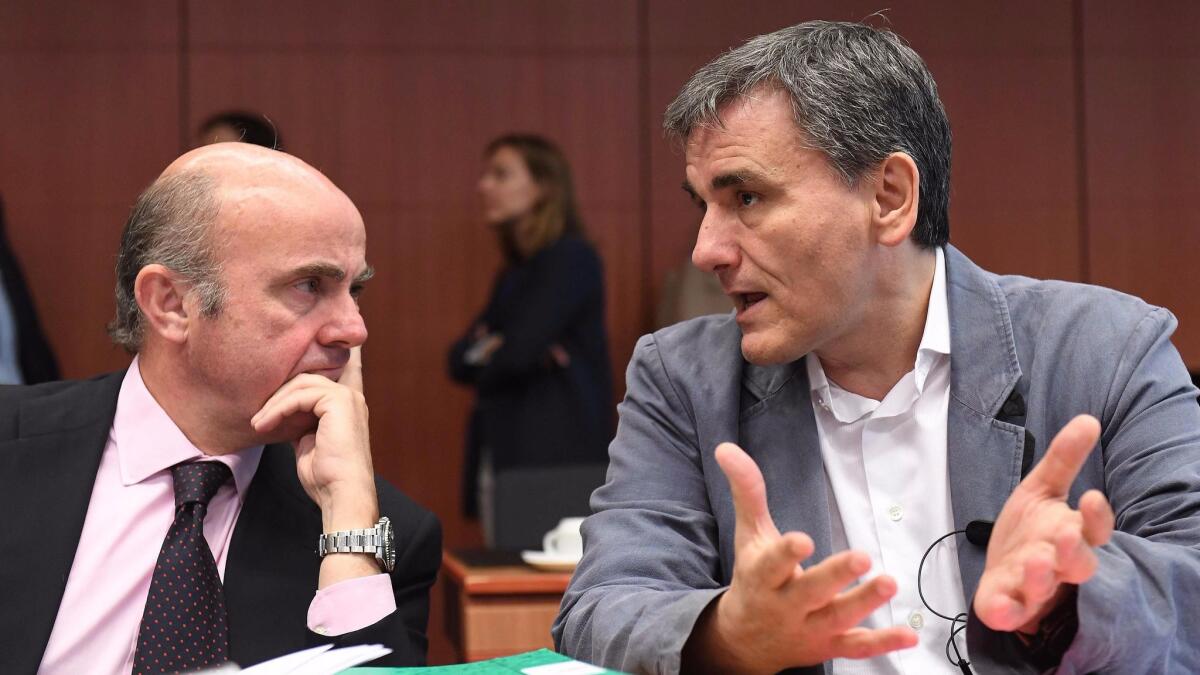 Greek Finance Minister Euclid Tsakalotos, right, speaks to Spanish Finance Minister Luis de Guindos Jurado during a Eurogroup finance ministers meeting on May 22, 2017, in Brussels.