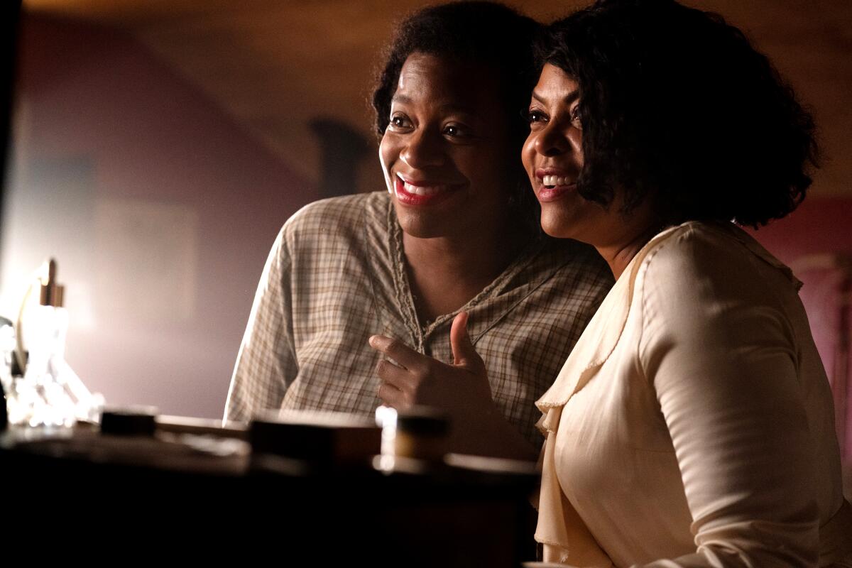 Two women stand together smiling in "The Color Purple."