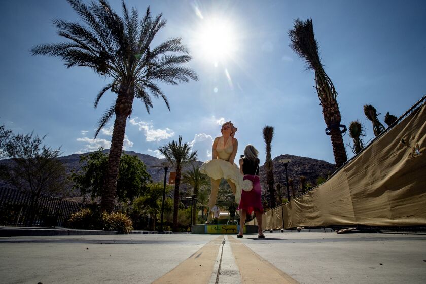 PALM SPRINGS, CA - JULY 8, 2021: As the sun beats down on the Forever Marilyn statue, tourists stop for quick photos in 110 degree temperatures on July 8, 2021 in downtown Palm Springs, California. Another heat wave is expected this weekend in Southern California.(Gina Ferazzi / Los Angeles Times)