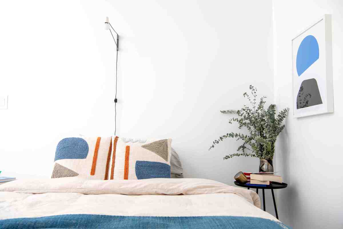 The bedroom features lighting by Brendan Ravenhill and silkscreen prints by Gabriel Stromberg.