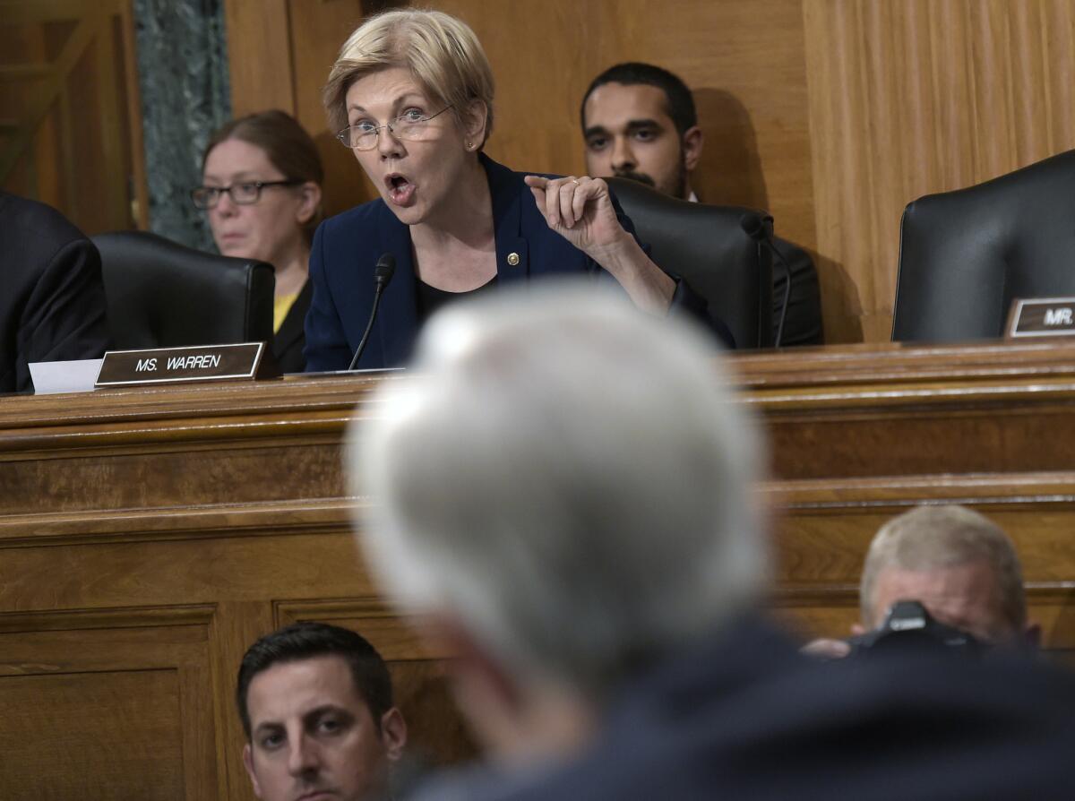 Sen. Elizabeth Warren (D-Mass.) questions Wells Fargo Chief Executive John Stumpf, foreground, during a Senate Banking Committee hearing Sept. 20. He retired last week.