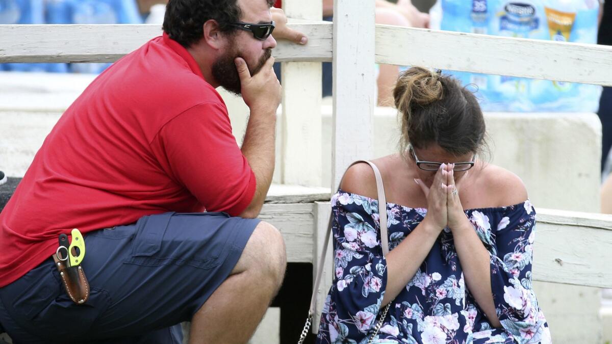 A woman prays outside the Santa Fe Independent School District Alamo Gym, where students and faculty gathered after the shooting.