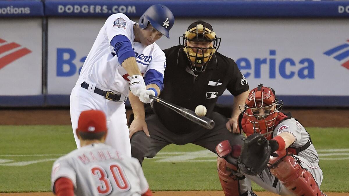 Los Angeles Dodgers' Chase Utley hits an RBI single off Cincinnati Reds starting pitcher Tyler Mahle, front, during the first inning.