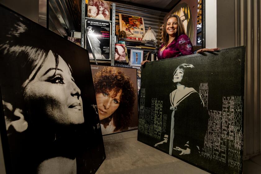 THOUSAND PLAMS, CA - NOVEMBER 29, 2023: Mara Papalas stands amidst just some of the hundreds of Barbra Streisand memorabilia inside a storage container on November 29, 2023 in Thousand Palms, California. Her father Louis Papalas bequeathed the largest Barbra Streisand collection in the world to his daughter after he died in March.(Gina Ferazzi / Los Angeles Times)