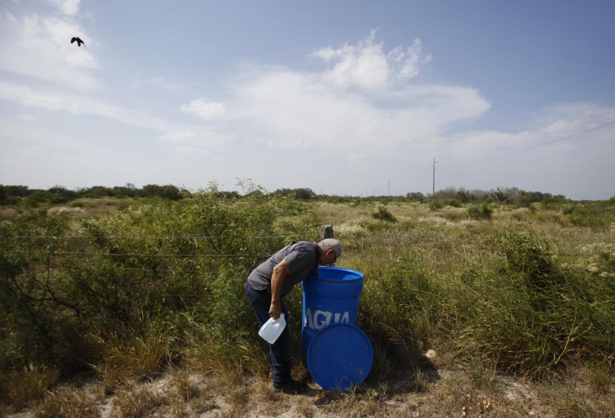 Eddie Canales of the South Texas Human Rights Center, prepares a water dispenser for immigrants walking across the scorching scrublands of southern Texas.