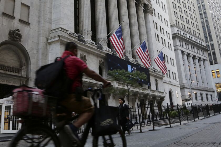 A man bikes past the New York Stock Exchange, Wednesday, Sept. 21, 2022, in New York. Stocks are off to a modestly higher start on Wall Street ahead of a widely expected interest rate increase by the Federal Reserve. The S&P 500 was up half a percent in the early going Wednesday, as was the Dow Jones Industrial Average. (AP Photo/Peter Morgan)