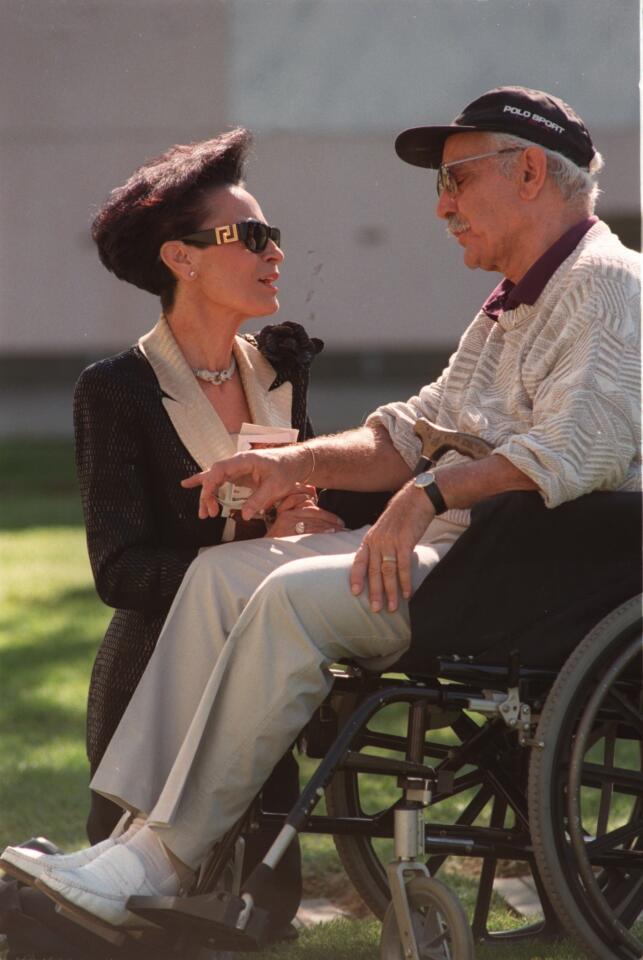 Anna Nateece, left, a designer for Liberace, chats with costume designer Michael Travis, who also worked for the glitzy entertainer, at a 1997 memorial service at Forest Lawn marking the 10th anniversary of Liberace's death. Travis died Thursday at his home in Studio City at the age of 86.