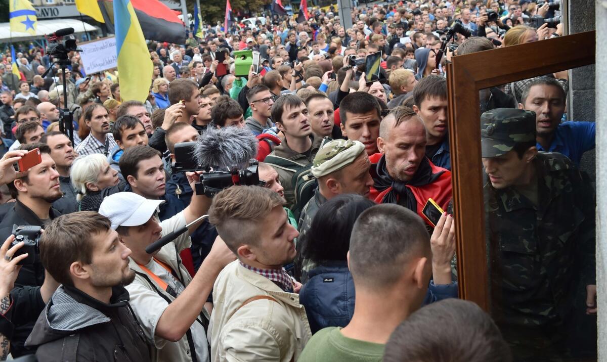 Protesters try to burst into the Ukrainian Defense Ministry in Kiev on Aug. 28 as they rally to demand help for volunteer troops surrounded by pro-Russia militants in the small city of Izvaryne, a suburb of Donetsk.