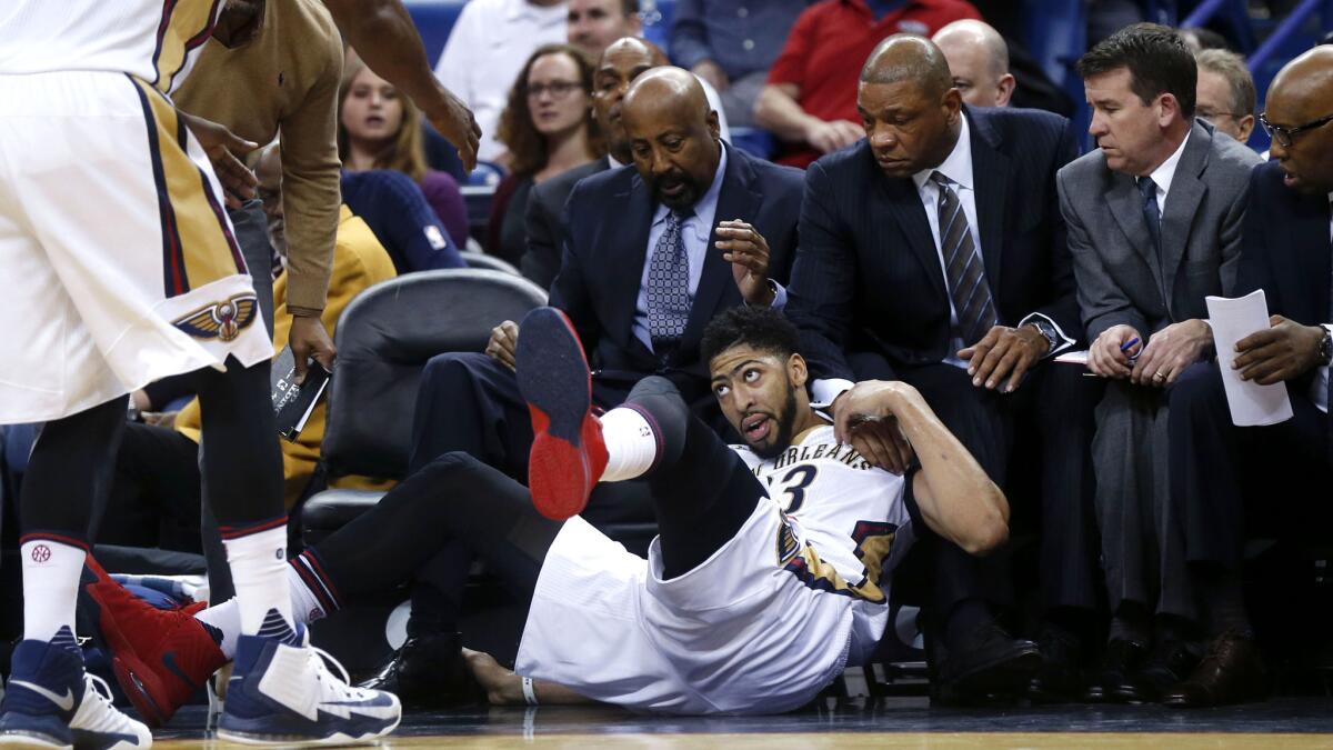 Pelicans forward Anthony Davis falls in front of Clippers Coach Doc Rivers during the first half of Wednesday night's game.