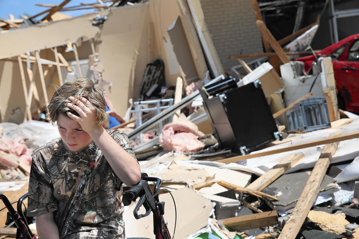 Sam Smith takes a break from helping a family friend salvage belongings from his business, which was destroyed when a tornado hit in Tupelo, Miss.