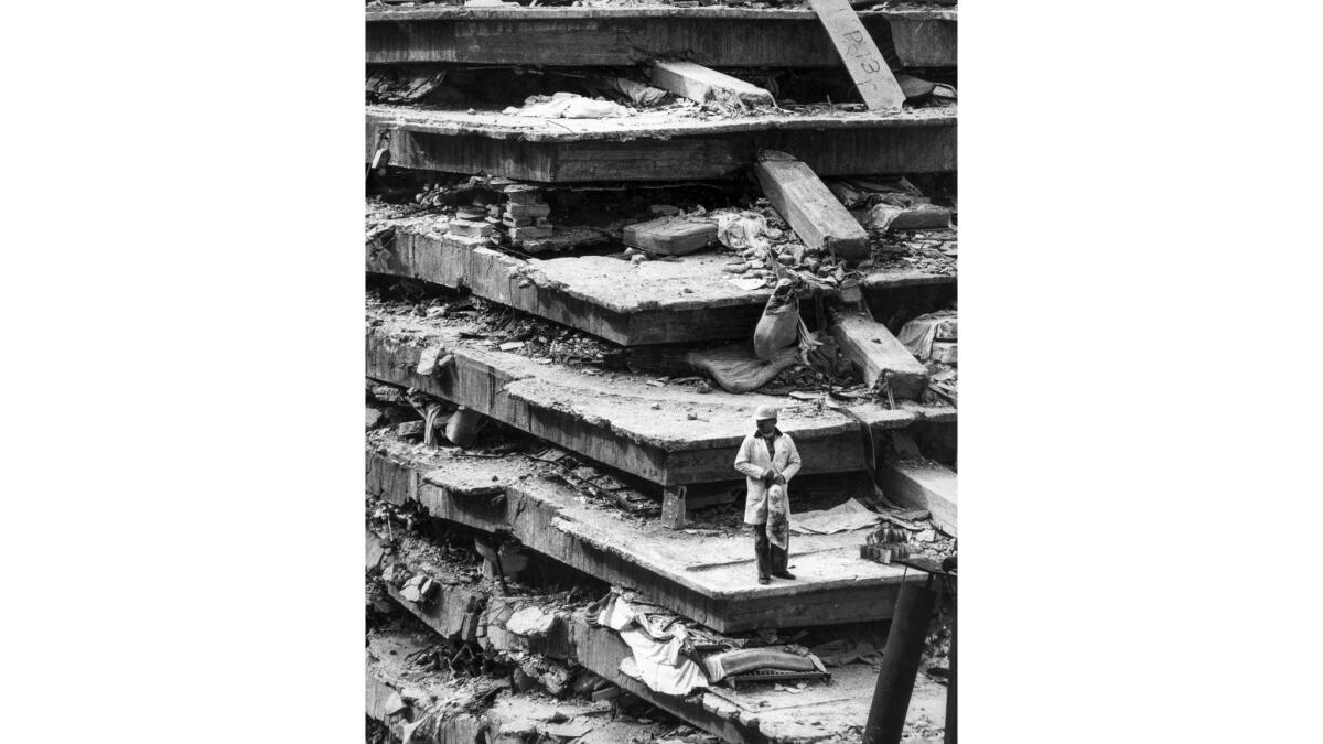 Sep. 19, 1985: A man stands on the wreckage of the General Hospital in Mexico City where collapsing floors killed 277 in earthquake.