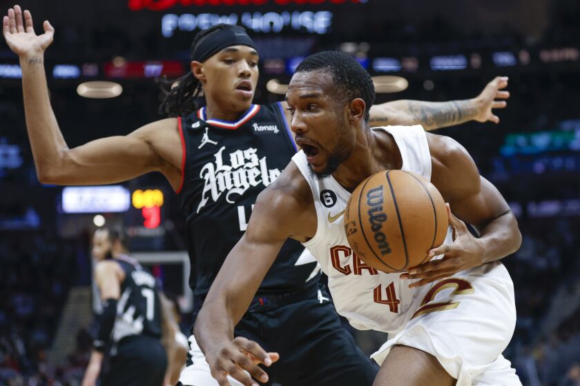 Cleveland Cavaliers forward Evan Mobley, right, drives against Los Angeles Clippers guard Brandon Boston Jr.