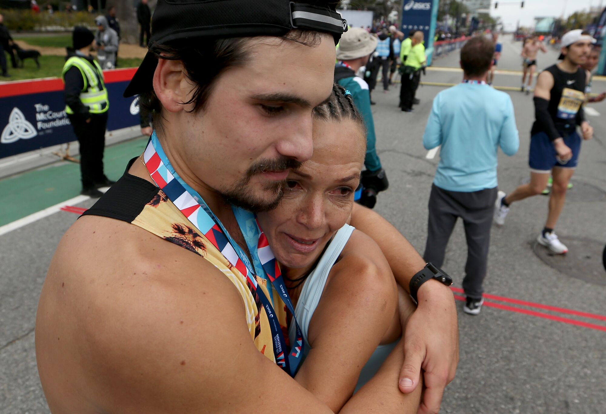 Two runners hug on the street after the Los Angeles Marathon.