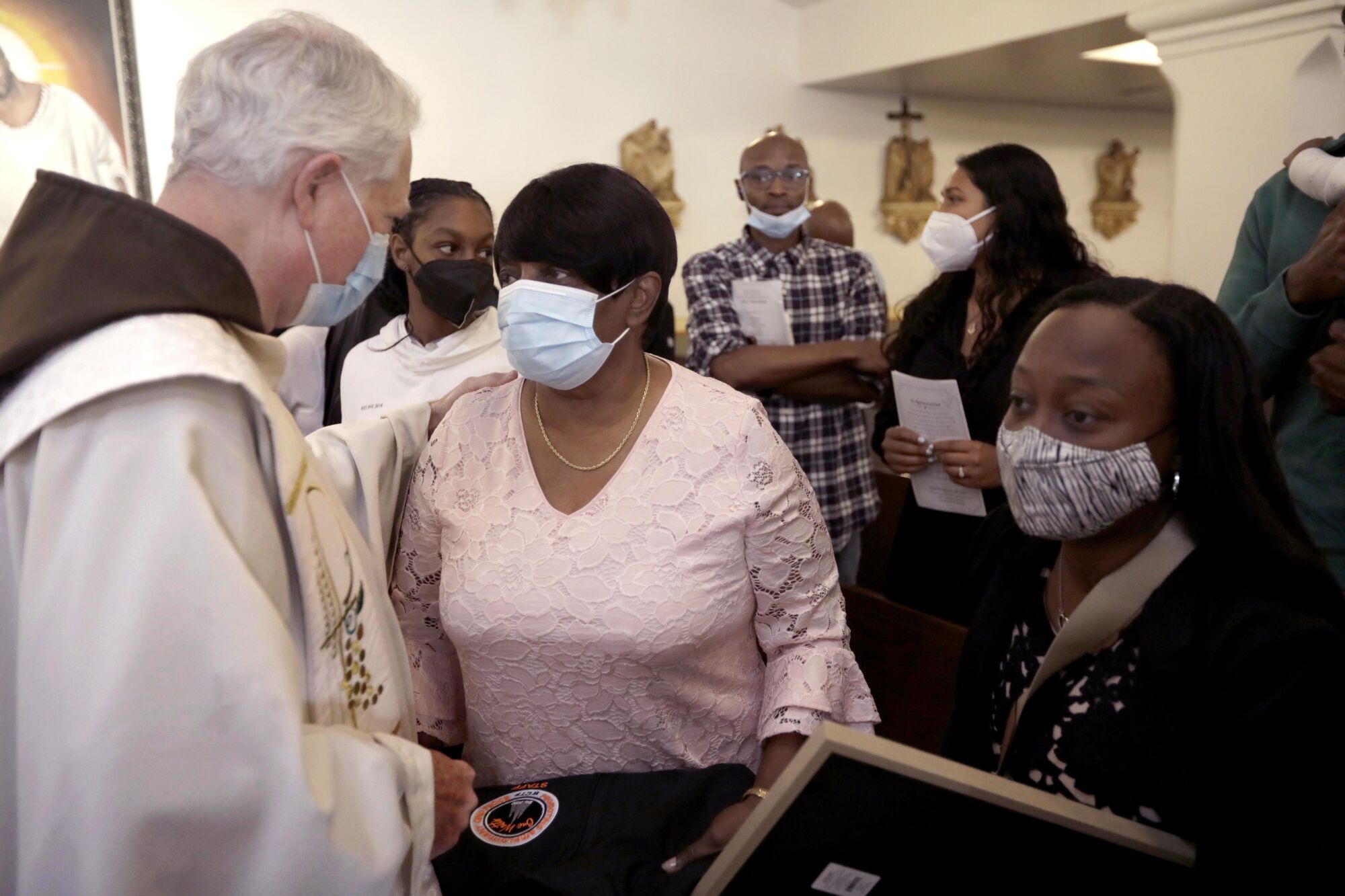 Margo Harris, right, shakes the hand of a Catholic cleric.
