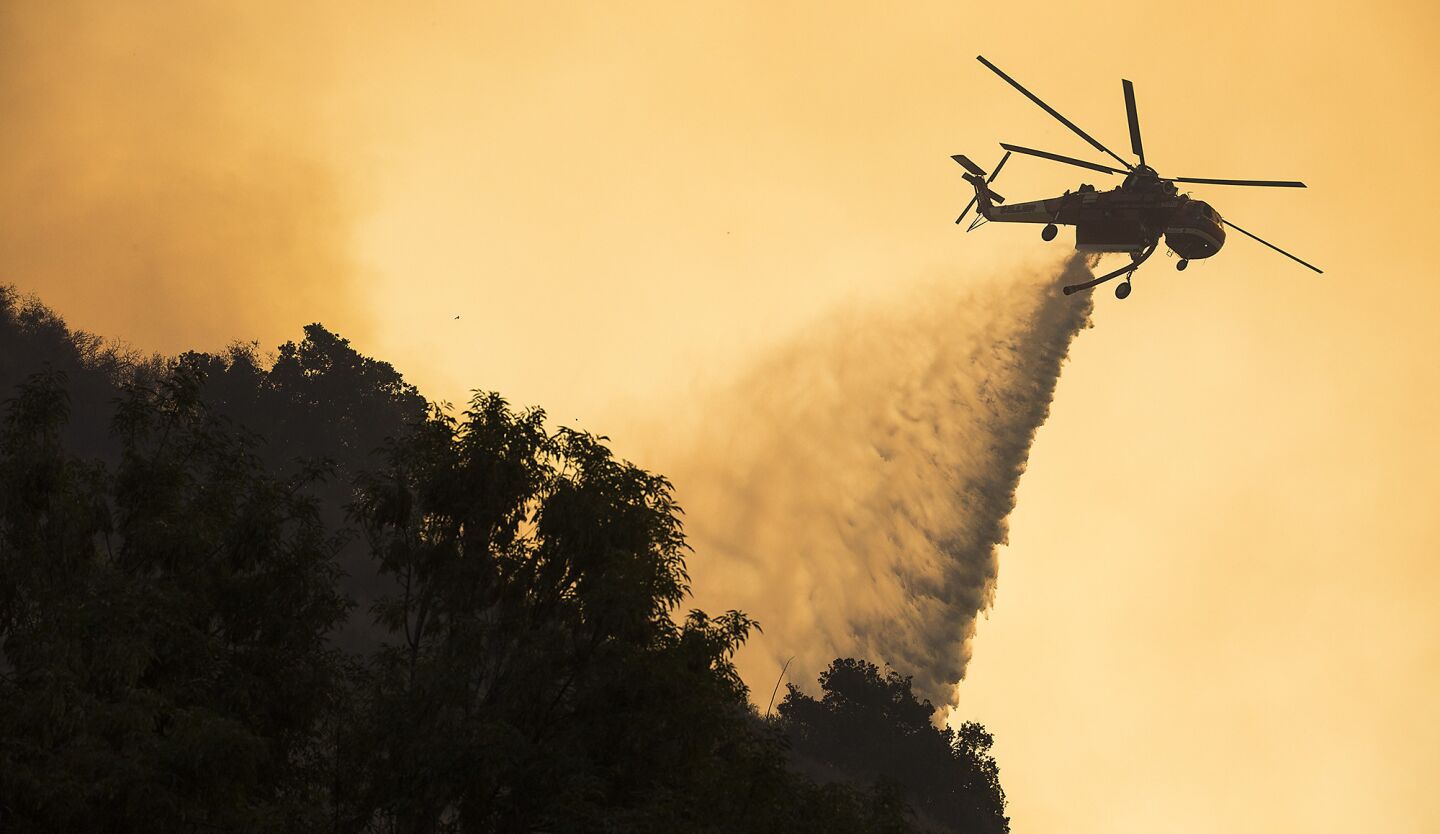 A helicoper drops water on the Sherpa fire in Santa Barbara County on Thursday morning.