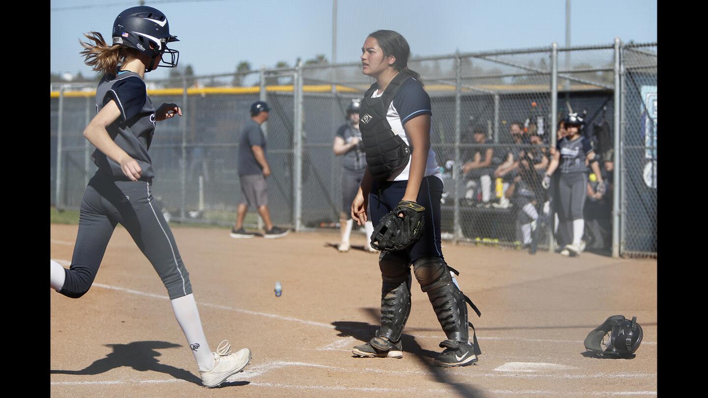Corona del Mar High catcher Sapphire Angely-Veron, right, looks on as Northwood scores a run during the fourth inning in a Pacific Coast League game on Wednesday, March 28.