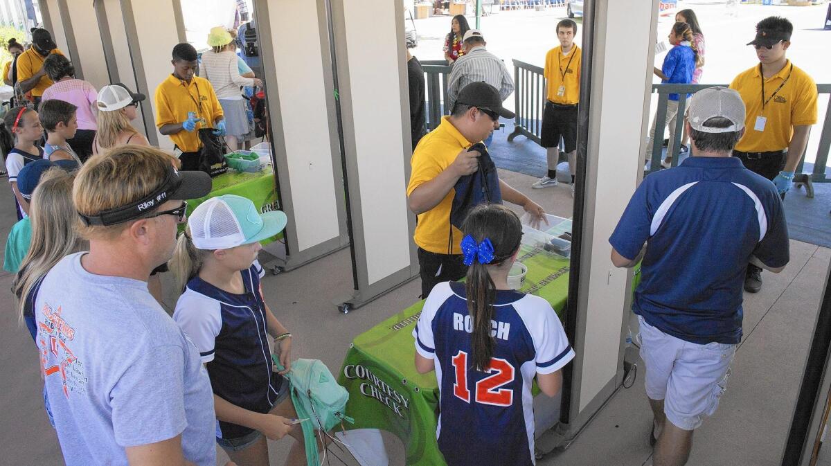Visitors enter metal detectors at the Orange County Fair’s Green Gate on Friday. This is the first year the fair has used walk-through metal detectors, which are placed at each entrance.