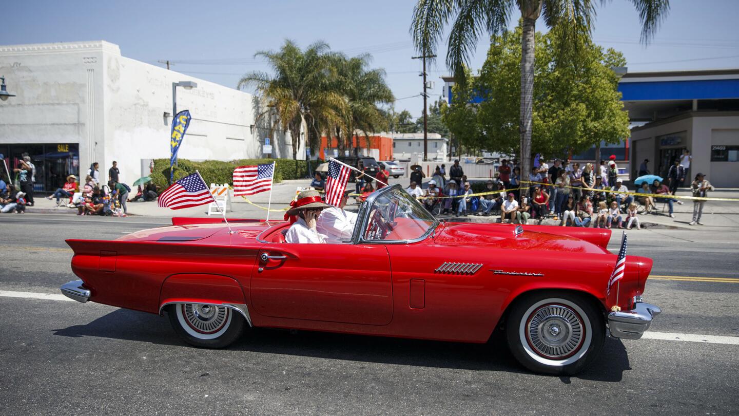 A vintage Ford Thunderbird following a parade route is a reminder of the community's heyday.
