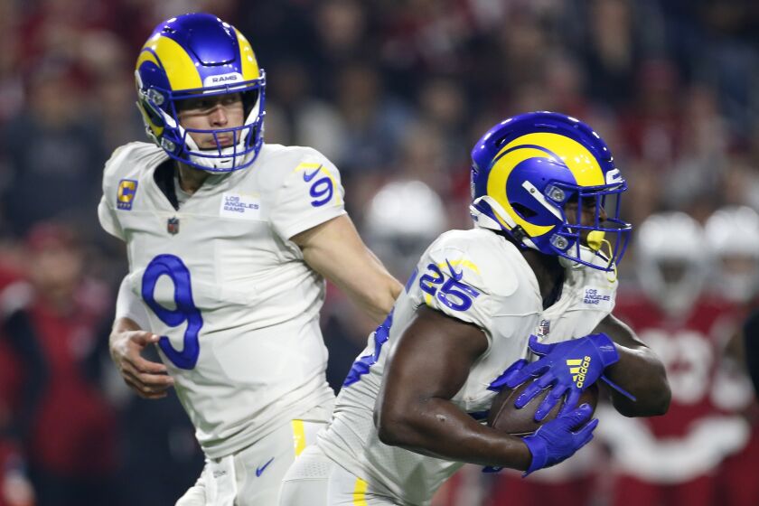 Los Angeles Rams quarterback Matthew Stafford (9) hands the ball off to Rams running back Sony Michel.