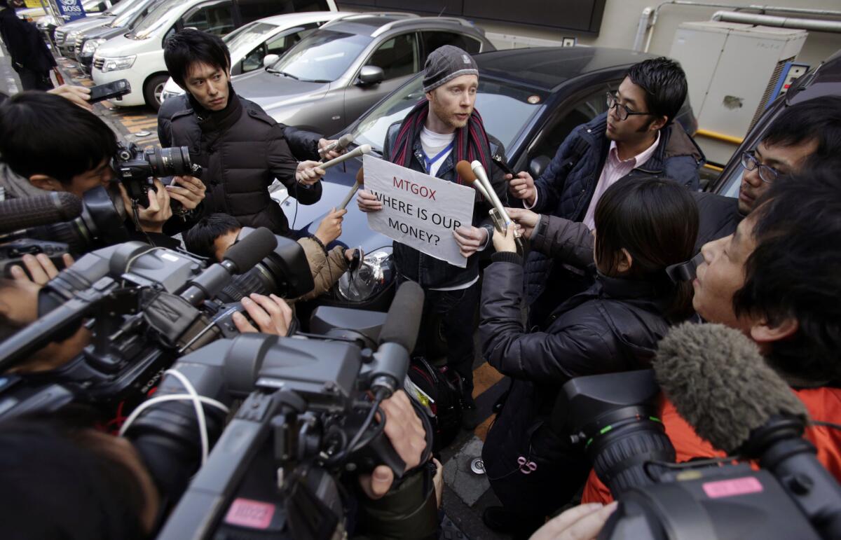 Bitcoin trader Kolin Burges is surrounded by media reporters and photographers during his protest outside an office building housing Mt. Gox in Tokyo. Prominent bitcoin supporters said the apparent collapse of the Tokyo-based Mt. Gox exchange was an isolated case of mismanagement.