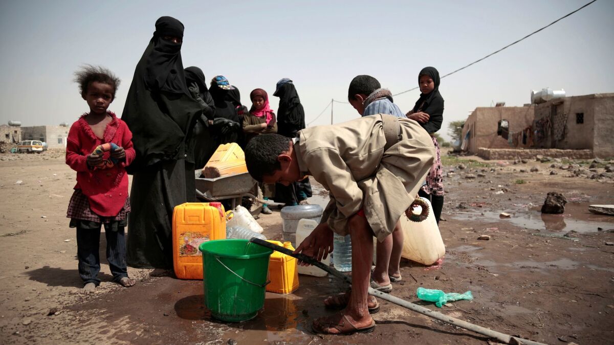 A boy fills a bucket with water from a well that is allegedly contaminated with cholera bacteria, on the outskirts of Sanaa, Yemen on July 12.