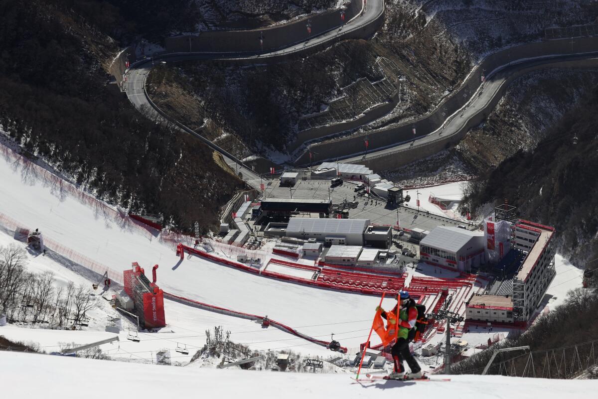 A course worker removes a gate on the men's downhill course after race was postponed because of high winds Sunday.