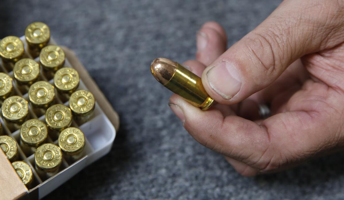 FILE - In this June 11, 2019, file photo, Chris Puehse, owner of Foothill Ammo, displays .45-caliber ammunition for sale at his store in Shingle Springs, Calif. A federal judge on Thursday, April 23, 2020, blocked a California law requiring background checks for people buying ammunition, ruling the restrictions violate the constitutional right to bear arms. U.S. District Judge Roger Benitez of San Diego ruled in favor of the California Rifle & Pistol Association, which asked him to stop the checks and related restrictions on ammo sales. (AP Photo/Rich Pedroncelli, File)