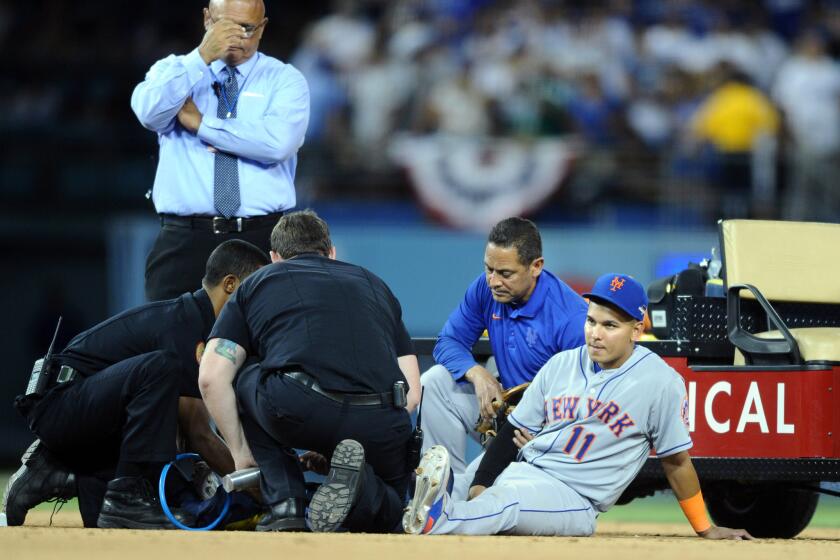 Mets shortstop Ruben Tejada is tended to by medical personel after a coillision in the seventh inning with Dodgers infielder Chase Utley in Game 2 of the NLDS.