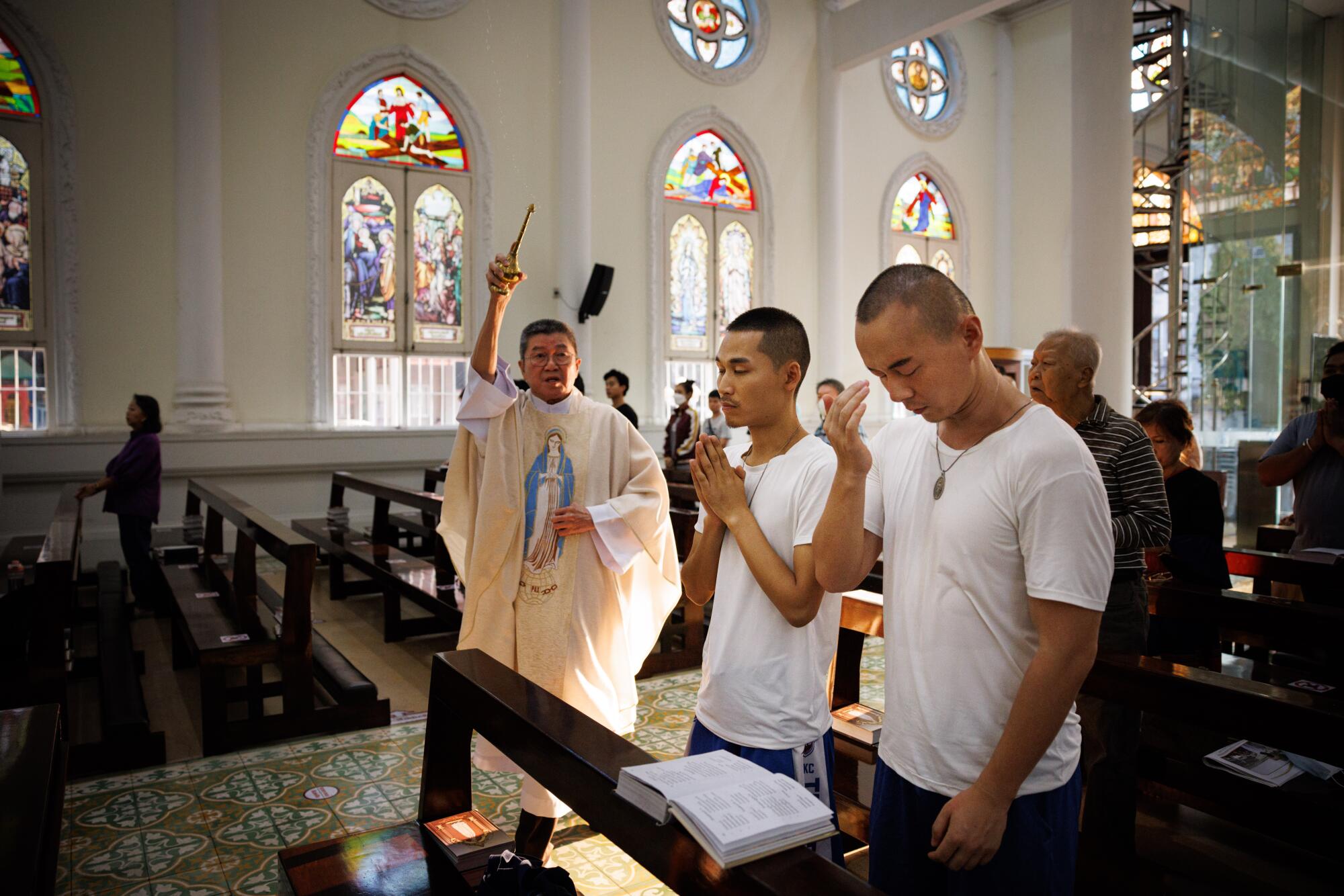 Jeffery Hu and his boyfriend, Wilfred Wu, attend Catholic mass at Our Lady Fatima Church on 