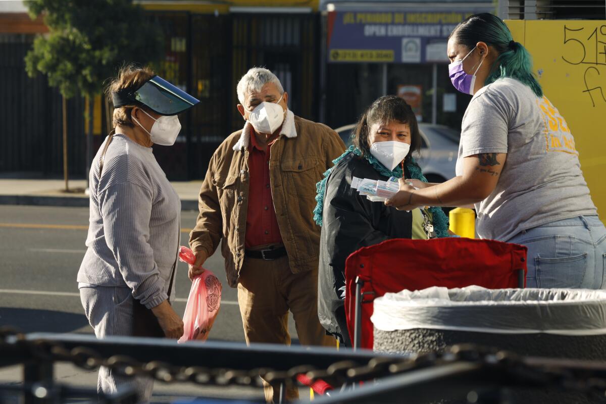 Health workers distribute COVID-19-related resources in Los Angeles.