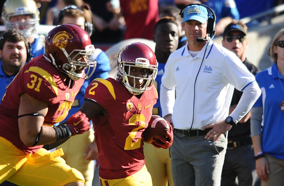 UCLA Coach Jim Mora gets a good view of USC cornerback Adoree' Jackson returning a punt for a touchdown in the first half.