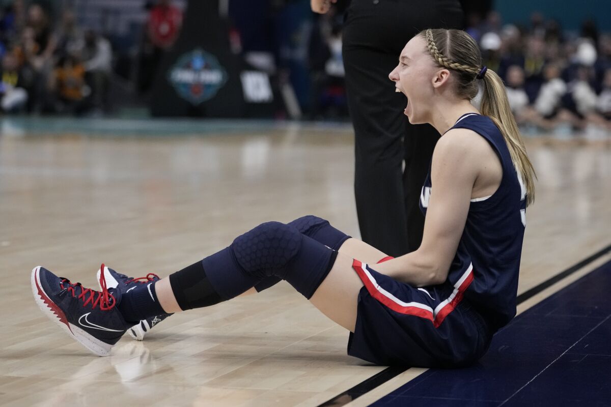 UConn's Paige Bueckers reacts after drawing a charge during the second half of a college basketball game in the semifinal round of the Women's Final Four NCAA tournament Friday, April 1, 2022, in Minneapolis. (AP Photo/Charlie Neibergall)