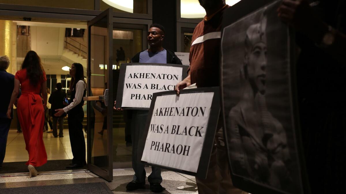 Kamal Mohsin holds a protest sign with other demonstrators outside Dorothy Chandler Pavilion on Saturday night. The protest was over the casting of a white singer in the title role of Los Angeles Opera's new production, "Akhnaten," about an Egyptian pharaoh.