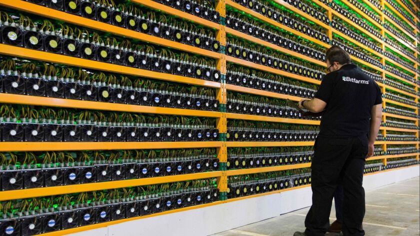 Technicians inspect bitcoin mining earlier this year at Bitfarms in the Canadian city of Saint Hyacinthe.