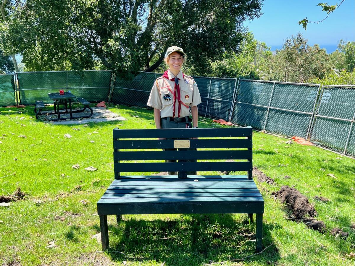 Laguna Beach resident Mason Bruderer stands behind a park bench that he created for his Eagle project.