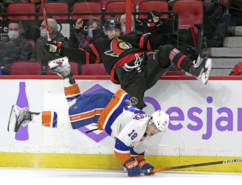 Ottawa Senators left wing Tim Stutzle (18) and New York Islanders left wing Anthony Beauvillier (18) fall after a hit during the second period of an NHL hockey game Tuesday, Dec. 7, 2021, in Ottawa, Ontario. (Justin Tang/The Canadian Press via AP)
