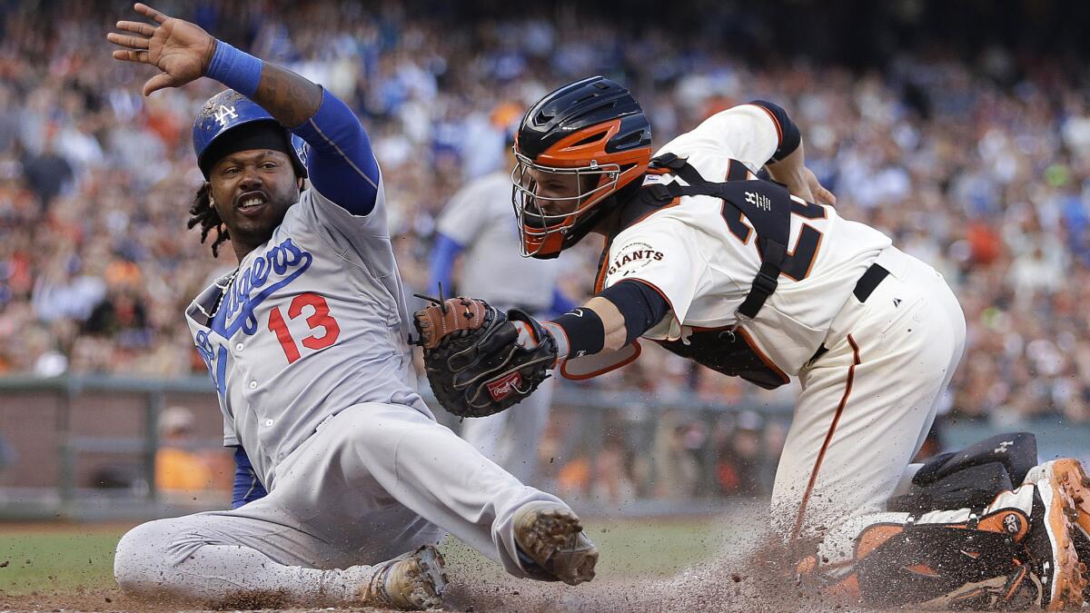 Dodgers shortstop Hanley Ramirez, left, beats the tag by San Francisco Giants catcher Buster Posey to score during the fifth inning of Sunday's game.