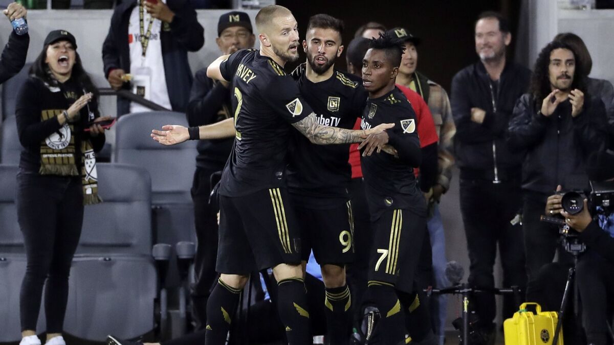 LAFC's Diego Rossi, center, is hugged by teammates Jordan Harvey, left, and Latif Blessing after scoring a goal against Real Salt Lake during the first half of a game March 23, 2019.