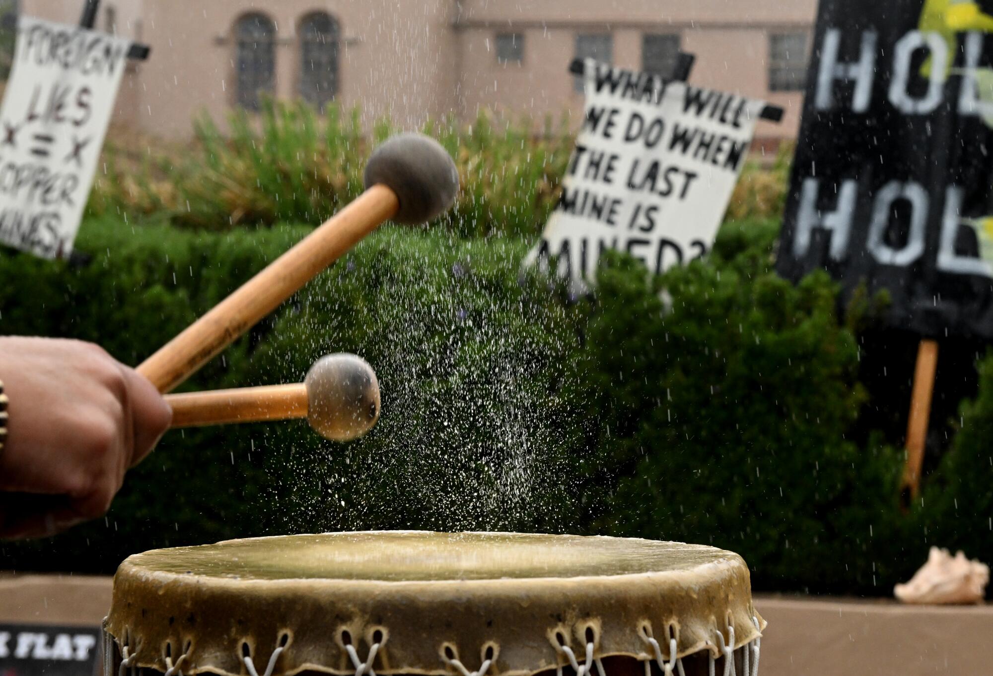 A drum with protest signs in the background