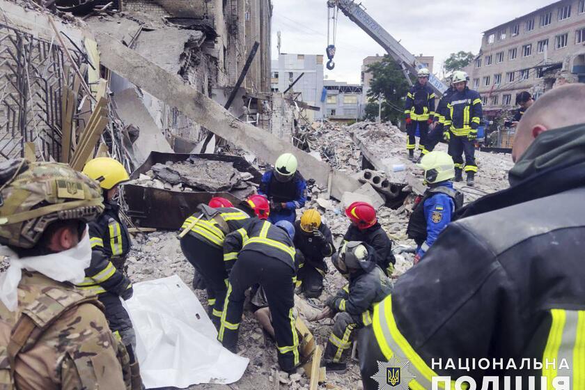 In this photo provided by the National Police of Ukraine, emergency services work near to the RIA Pizza restaurant destroyed by a Russian attack in Kramatorsk, Ukraine, Wednesday, June 28, 2023. (National Police of Ukraine via AP)