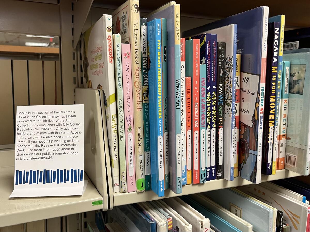 Space on book shelves once filled with children's books now contain a note that certain titles may have been relocated