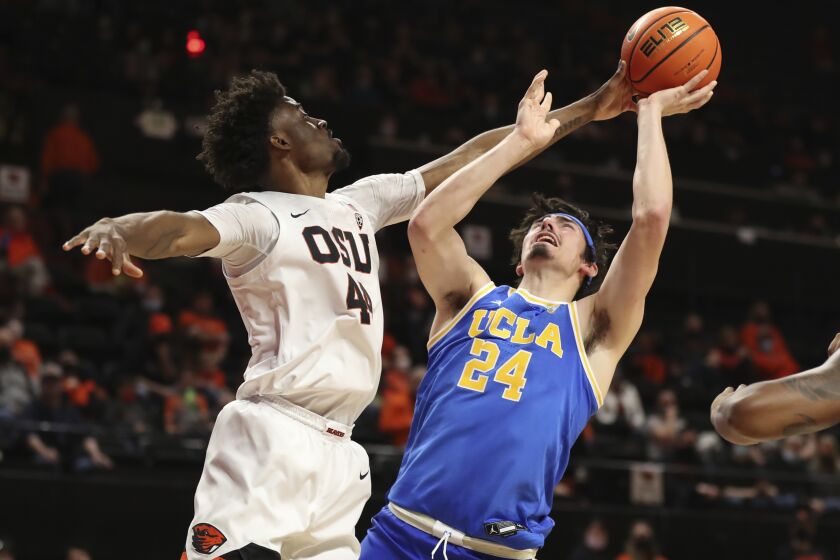 Oregon State forward Ahmad Rand, left, tries to block a shot by UCLA forward Jaime Jaquez Jr., right, during the second half of an NCAA college basketball game on Saturday, Feb. 26, 2022, in Corvallis, Ore. UCLA won 94-55. (AP Photo/Amanda Loman)