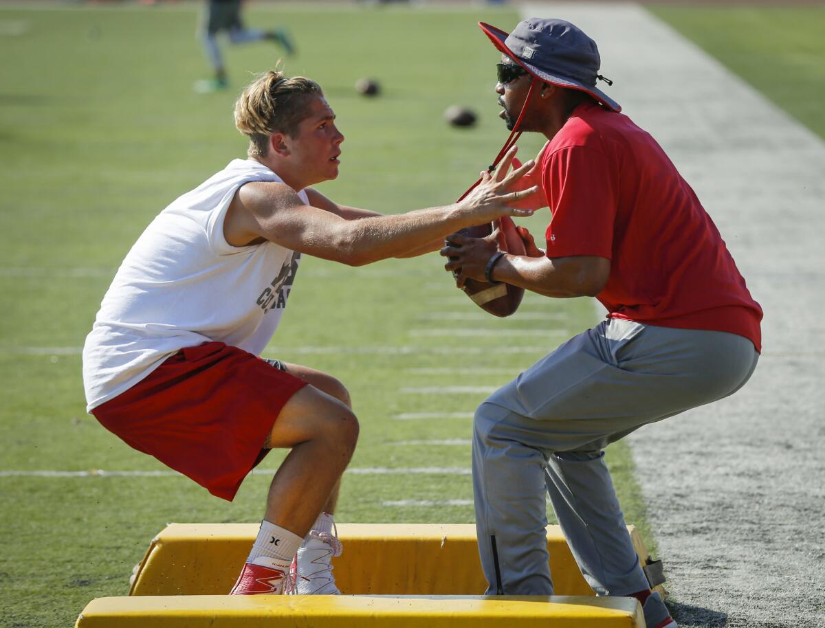 Mission Viejo High School defensive backs coach Robert Lee, right, runs drills with a high school player during a satellite camp featuring coaches from the University of Oregon.