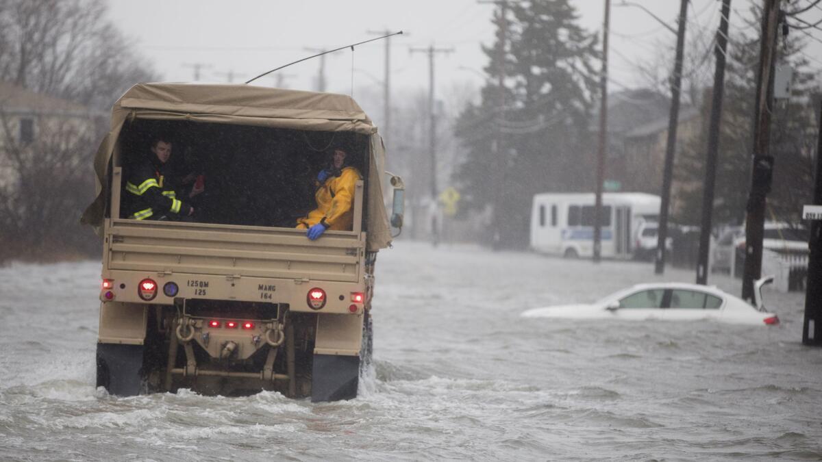 A National Guard vehicle takes emergency workers to residents trapped in Quincy, Mass., by floodwaters from the powerful storm that hit the East Coast on Friday.