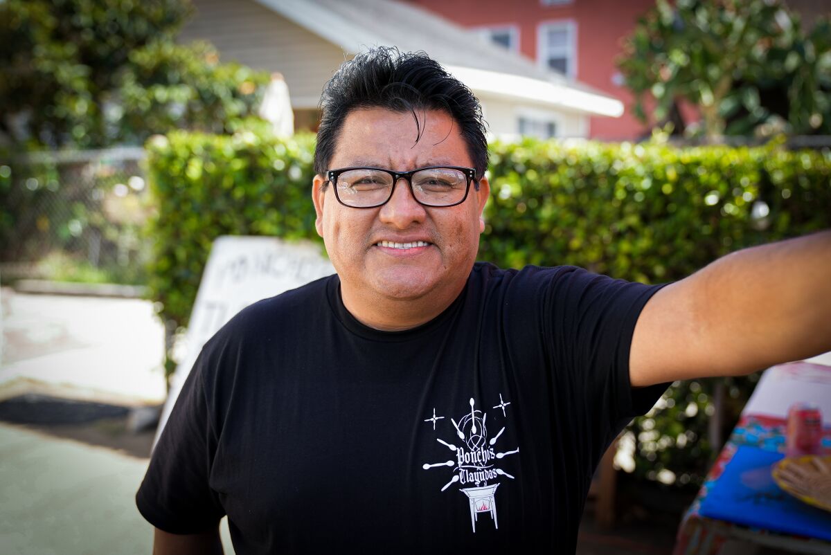 Alfonso "Poncho" Martinez, wearing black-framed glasses and a Poncho's Tlayudas black T-shirt.