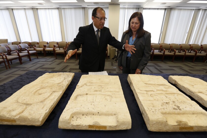 Roberto Archila, consul general for the Guatemalan Consulate, Los Angeles, on Friday discusses Mayan artifacts with Deirdre Fike, assistant director in charge at the L.A. FBI field office.